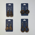 Four pairs of handcrafted wooden earrings on blue cards against a white background